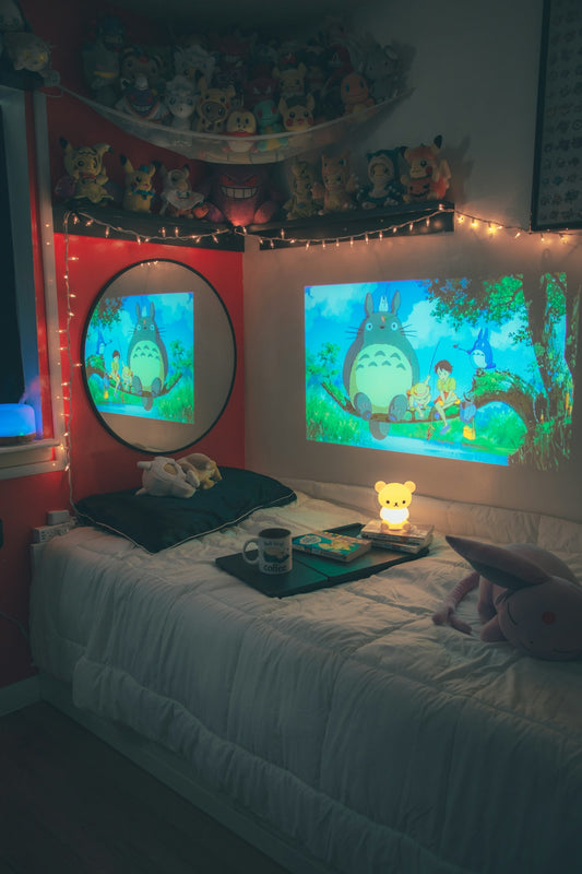 A room with a bed and two monitors on the wall